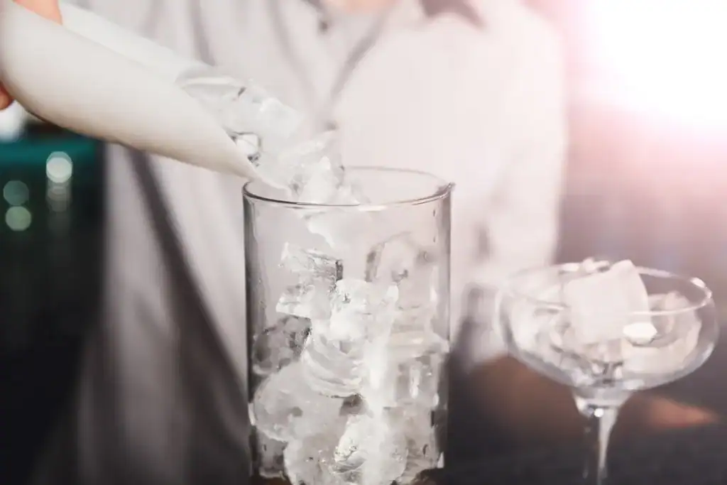 Bartender pouring food-grade crushed ice into a cocktail glass, supplied by Supreme Ice